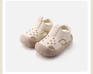 Detailed view of cream-colored baby hollow leather sandals with soft anti-slip rubber soles.