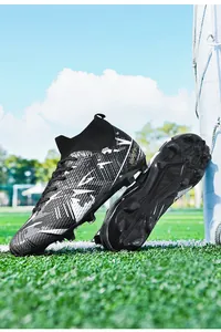 Macro detail of high-top professional soccer cleats showing firm ground studs on a grass field