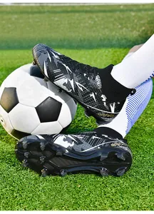 Close-up of high-top soccer cleats with graphic pattern on turf