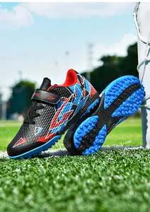 Detail van kindervoetbalschoenen met getextureerd bovenwerk en blauwe TF rubberen nopjeszool.