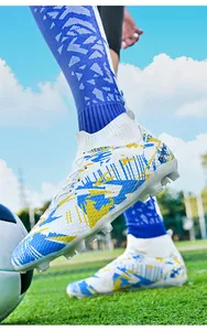 Close-up of white high-top soccer cleats with blue and yellow patterned design