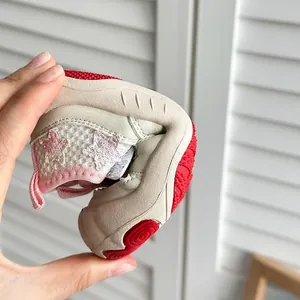 Sandalo flessibile beige per bambini con suola rossa che mostra alta piegabilità.