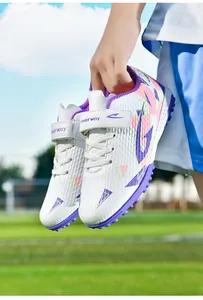 Close-up van witte kindervoetbalschoenen voor kunstgras met paarse klittenbandsluiting.