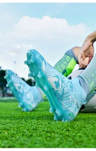 Close-up detail of light blue high-top soccer cleats with firm ground long studs