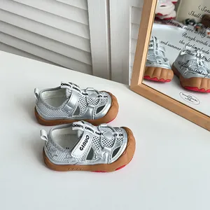 Primo piano di sandali per bambini argento a punta chiusa con tomaia in mesh e stelle