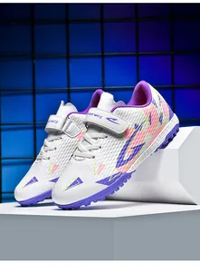 Detailopname van kindervoetbalschoenen met paarse rubberen TF-zolen voor gras