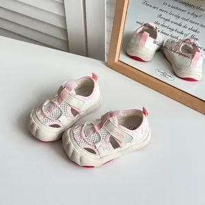Primo piano di sandali per bambini in rete rosa e bianca con cinturino in velcro