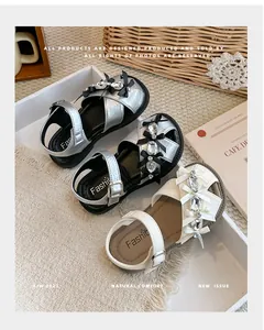 Nahaufnahme von Mädchen-Prinzessin-Sandalen mit glänzenden Strasssteinen und Schleifen