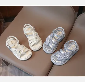 Detail view of white and silver girls' sandals with elegant bow and pearl accents