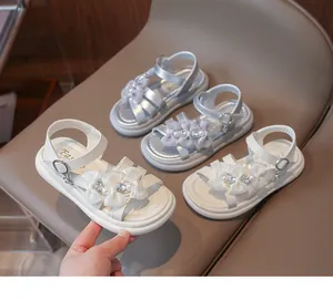 Detailed view of white girls' princess sandals with elegant butterfly bows and pearls