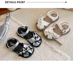 Detailansicht von Mädchen-Prinzessin-Sandalen mit Strasssteinen und Schleifen in Silber