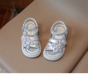 Detailed view of silver girls princess sandals featuring delicate pearl and bowknot decorations