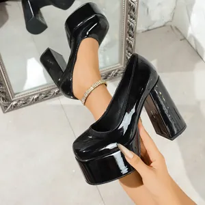 Close-up of black patent leather platform high heel pumps with chunky block heel.