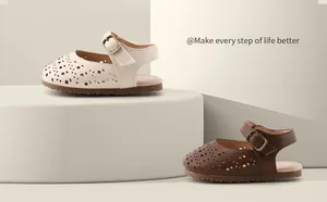 Photo de studio de sandales ajourées pour bébé en crème et marron, semelles souples.