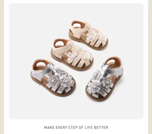 Dettaglio di sandali floreali per bambini con suole morbide e perle in beige e argento
