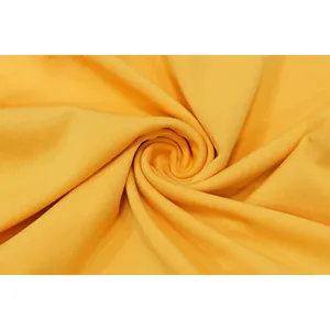 Macro detail of soft yellow knit fabric showing delicate texture and spiral drape