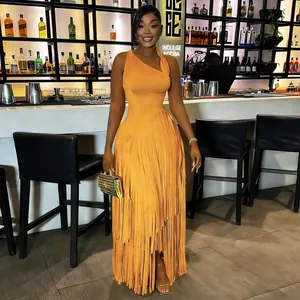 Detailed view of elegant orange one-shoulder fringe maxi dress in a bar setting