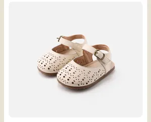 Gros plan sur des sandales crème pour bébé fille avec motif ajouré et semelles souples