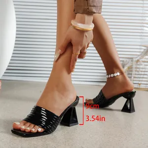 Dettaglio ravvicinato di sabot neri a punta quadrata con un elegante tacco a blocco da 9 cm