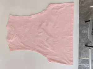 Flat lay of a light pink loose fit men's sports tank top for gym training