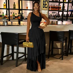 Close-up of elegant black tassel dress with one-shoulder design in a chic bar setting.