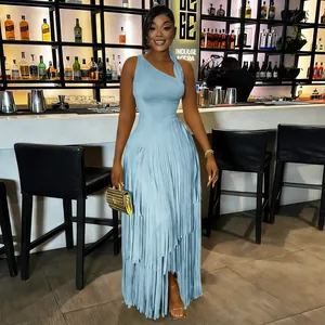 Elegant light blue one-shoulder maxi dress with tiered fringe detail in bar setting.