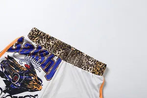 Close-up of leopard print waistband and graphic art print on high-waisted white shorts