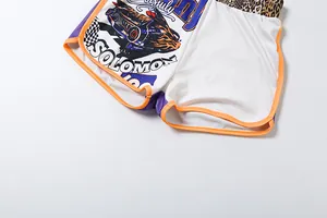 Detail view of sporty shorts featuring car graphic print and orange piping trim
