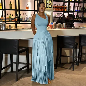 Elegant light blue sleeveless maxi dress with layered fringe skirt in a chic bar setting.