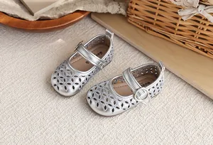 Chaussures Mary Jane argentées pour filles avec motif ajouré et semelle souple.