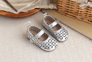 Détail de sandales Mary Jane argentées ajourées pour filles avec semelles souples