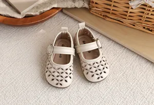 Gros plan de chaussures Mary Jane beiges ajourées pour filles avec motif floral