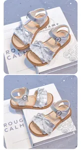 Detail view of silver girls' princess sandals with lace bow and soft durable sole