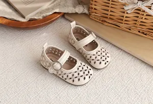 Détail de sandales Mary Jane beiges ajourées pour filles avec semelle souple.