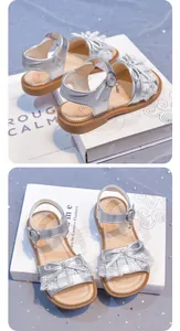 Silver metallic girls sandals with decorative lace bow and soft rubber sole