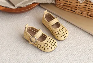 Gros plan sur les motifs de fleurs ajourés des chaussures Mary Jane jaunes filles
