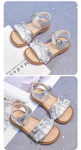 Close-up detail of stylish silver girls' sandals featuring lace bow and soft sole