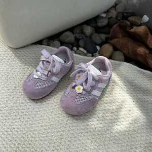 Close-up of purple mesh sneakers for baby girls featuring cute flower decorations.