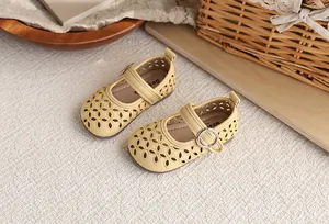 Gros plan détaillé de sandales Mary Jane jaunes pour filles avec motifs floraux ajourés