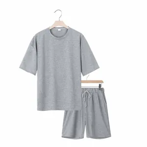 Detalle de conjunto de dos piezas gris para hombre en perchas, diseño minimalista.