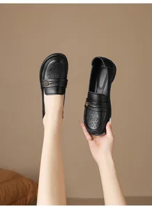 Detailed view of breathable black perforated leather loafers with elegant floral embellishment