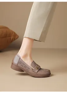 Detail view of breathable laser-cut patterns and gold flower buckle on soft mother shoes