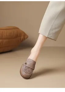 Detail shot of breathable hollow-out leather loafers for women with floral pattern.