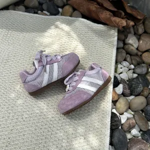 Detailed macro shot of breathable lavender mesh girl sneakers with daisy flower accent