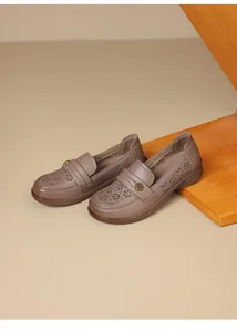 Detailed view of breathable hollow-out design and flower buckle on taupe loafers