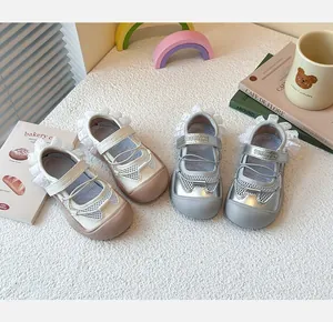 Detail of girls mesh ballet sandals with lace trim in silver and beige colors.