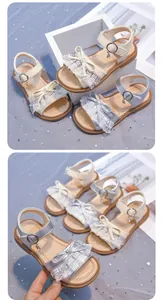 Detailed view of girls' lace sandals with bow accents and soft soles in silver and beige