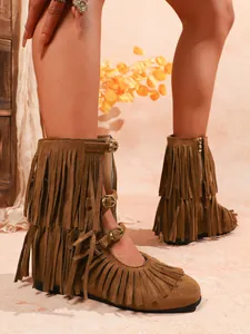 Detail der braunen Westernstiefel mit Fransen und Metallschnallen