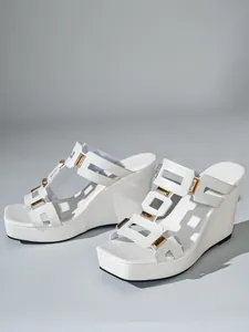 Gedetailleerde close-up van witte sleehaksandalen met vierkante neus en goud