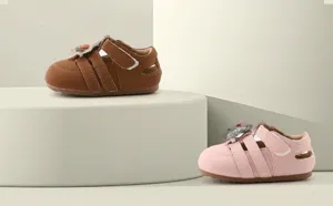 Detailansicht niedlicher Lauflernschuhe für Babys in den Farben Braun und Rosa.